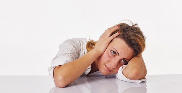 Imagen de mujer aburrida y cansada detrás de la mesa