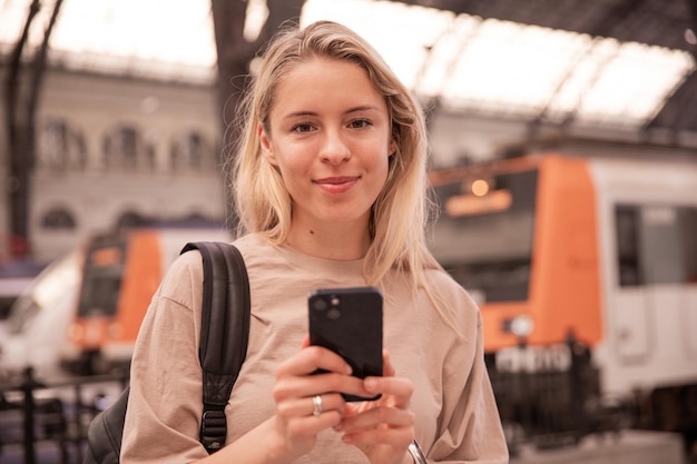 Imagen de una mujer atractiva mirando la cámara y sosteniendo el teléfono