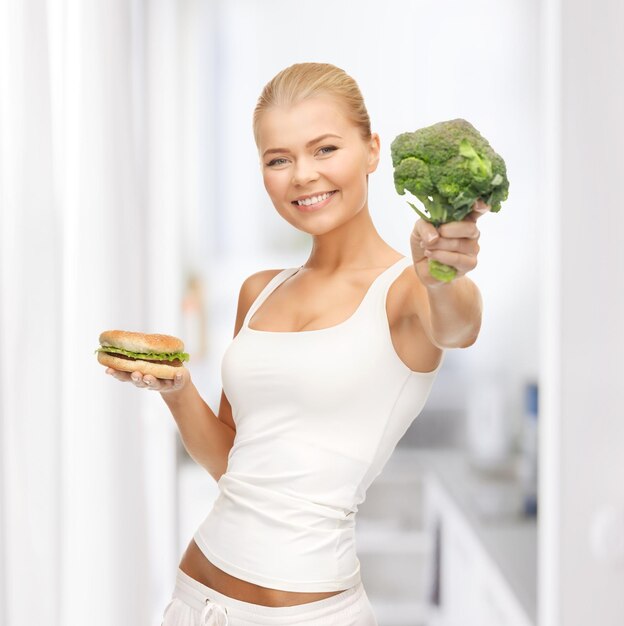 Imagen de mujer deportiva con brócoli y hamburguesa