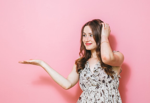 La imagen de una mujer emocionada presentando gestos sobre rosa
