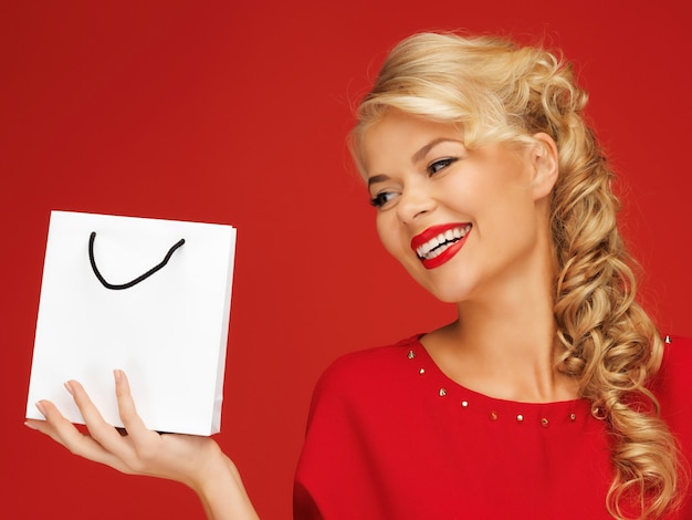 imagen de mujer encantadora en vestido rojo con bolsa de compras