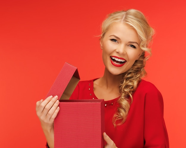 imagen de mujer encantadora en vestido rojo con caja de regalo abierta