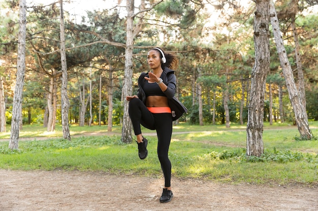 Imagen de mujer enérgica de 20 años vistiendo chándal negro, haciendo deporte en Green Park