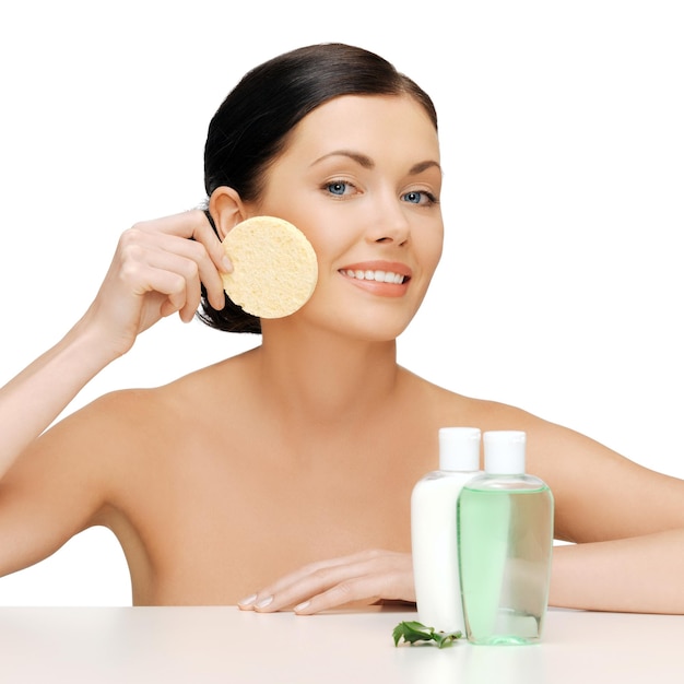 imagen de mujer con esponja y botellas cosméticas