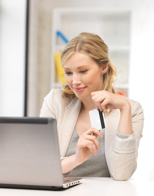 imagen de mujer feliz con computadora portátil y tarjeta de crédito.