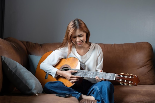Imagen de mujer hermosa feliz tocando la guitarra y componiendo canciones