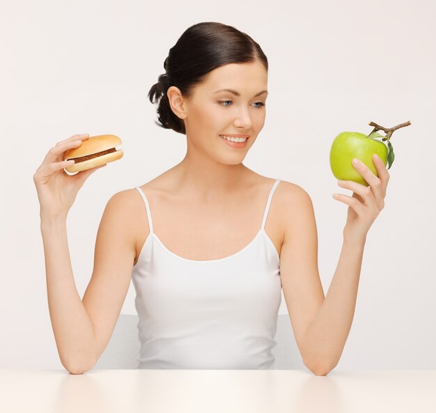 imagen de mujer hermosa con hamburguesa y manzana