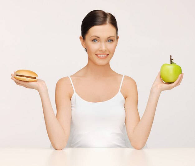 imagen de mujer hermosa con hamburguesa y manzana