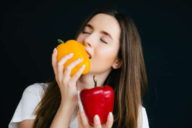 Imagen de mujer hermosa joven positiva emocional posando y sosteniendo paprika