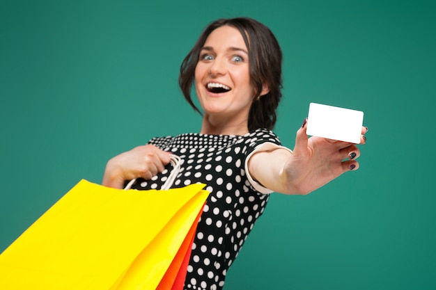 Foto imagen de mujer hermosa en ropa moteada de pie con compras y corte en manos