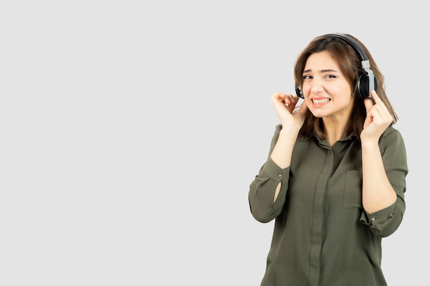 Imagen de mujer joven y atractiva en auriculares escuchando una canción. Foto de alta calidad