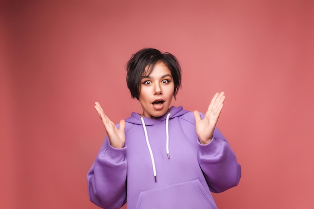 Una imagen de una mujer joven gritando emocionada de pie aislada en un fondo rosa Un retrato de estudio de cámara de visualización