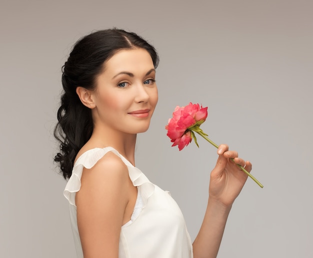 Foto imagen de mujer joven sonriente oliendo flores