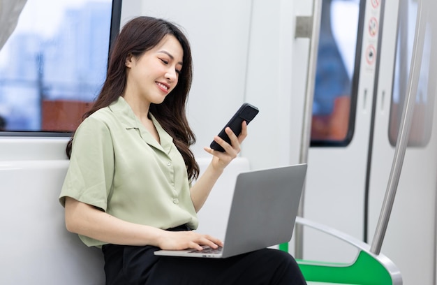 Imagen de una mujer de negocios asiática usando un teléfono en el tren