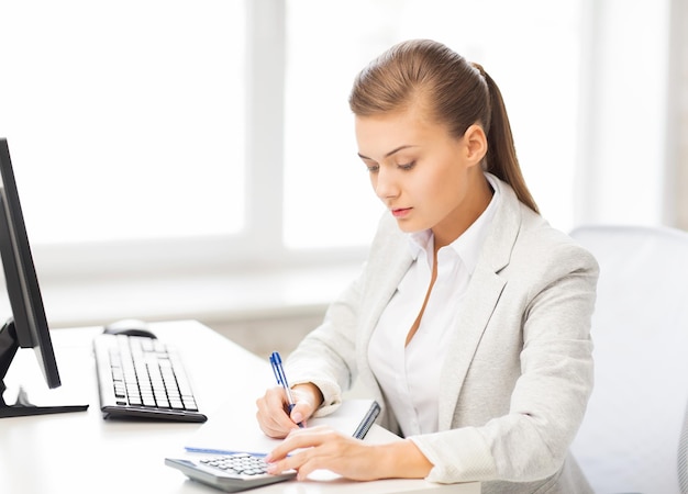 imagen de mujer de negocios con cuaderno y calculadora