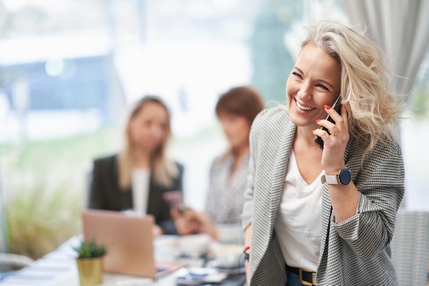 Imagen de mujer de negocios con teléfono celular en reunión