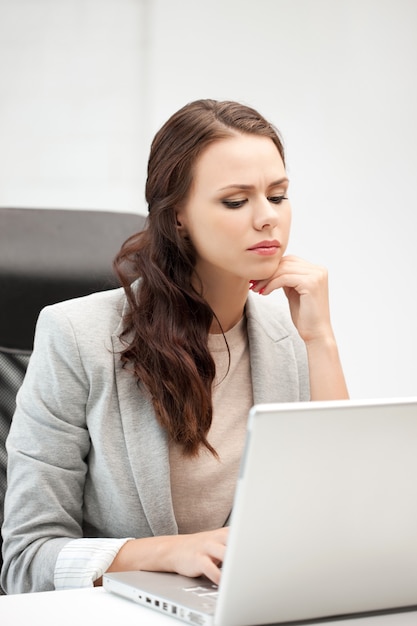 imagen de mujer pensativa con ordenador portátil