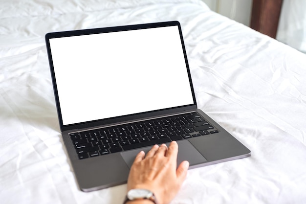 Imagen de una mujer que usa y escribe en una computadora portátil con un teclado de pantalla de escritorio en blanco en la cama