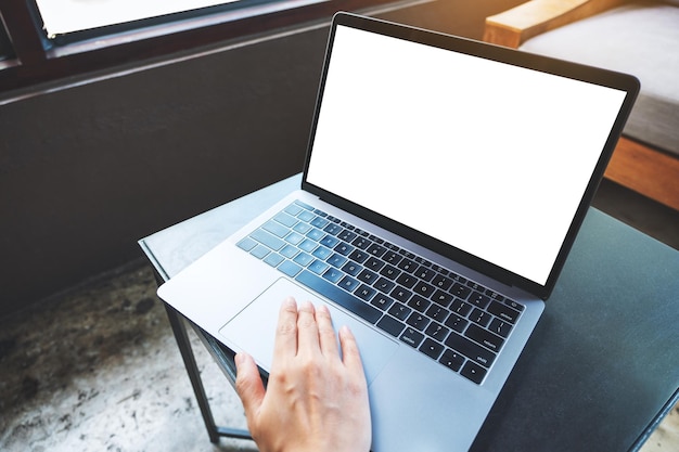 Imagen de una mujer que usa y toca el panel táctil de una computadora portátil con una pantalla de escritorio en blanco en la mesa