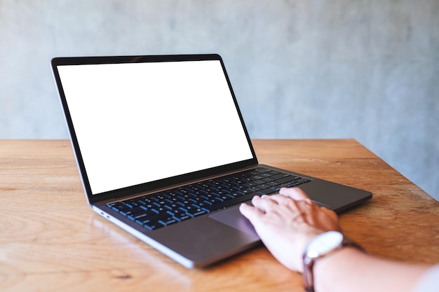 Imagen de una mujer que usa y toca el panel táctil de una computadora portátil con una pantalla de escritorio en blanco en la mesa