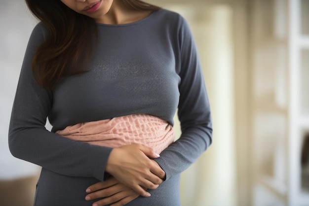 Foto imagen de una mujer sosteniendo su estómago debido al dolor