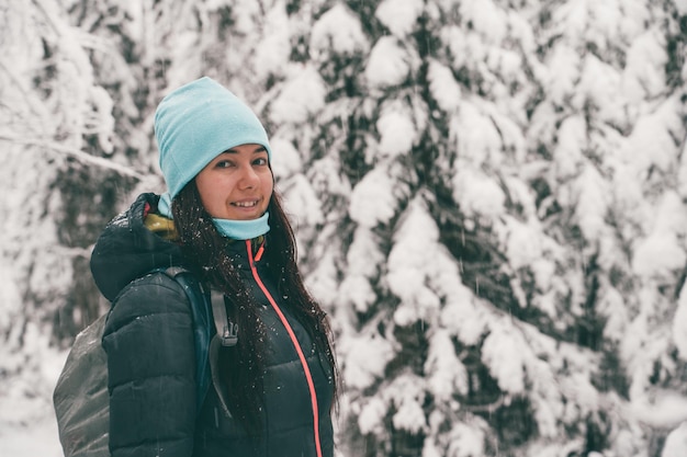 Imagen de mujer turista caminando en el bosque de invierno