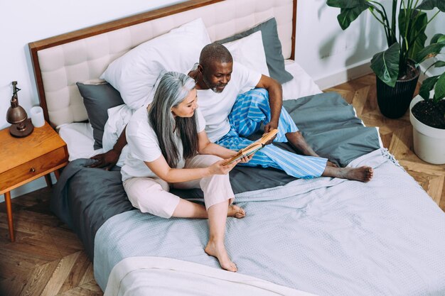 Imagen de narración de una pareja mayor leyendo un libro en la cama