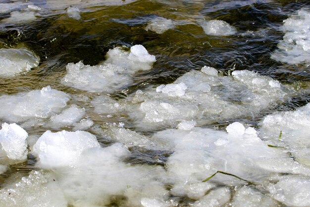 una imagen de nieve derretida flota a lo largo de un pequeño río
