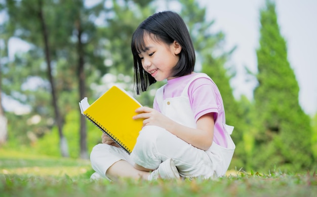 Imagen de una niña asiática estudiando en el parque