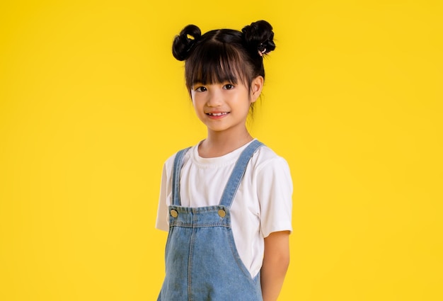 Foto imagen de una niña asiática posando sobre un fondo amarillo