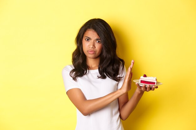 Imagen de niña disgustada que se niega a comer un pastel