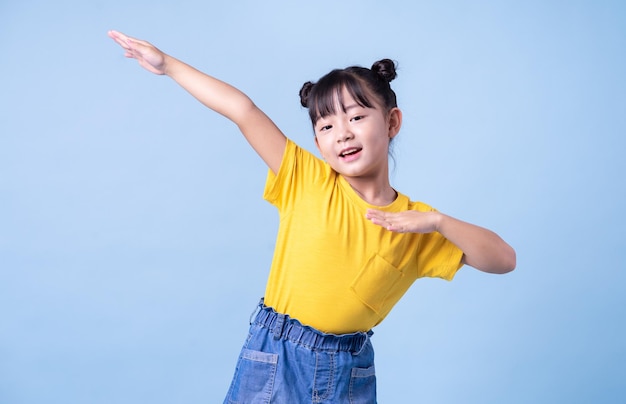 Imagen de niño asiático posando sobre fondo azul.