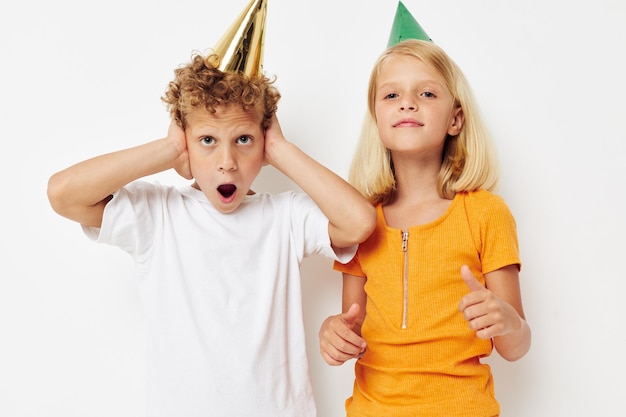 Imagen de niño y niña positivos con gorras en la cabeza entretenimiento de vacaciones fondo claro