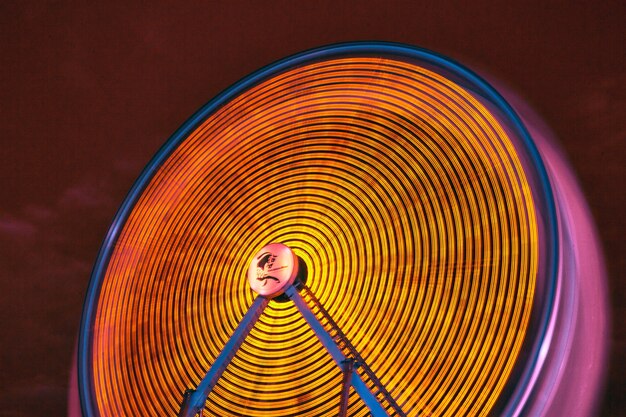 Imagen de la noria giratoria amarilla por la noche en infrarrojos en un carnaval o feria