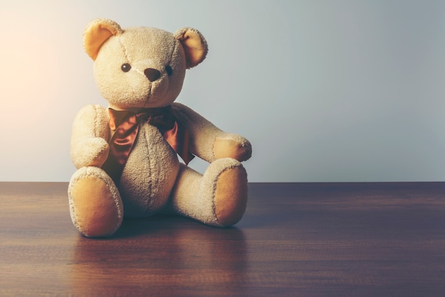 Imagen oscura de la colocación de la lágrima de peluche en la mesa de madera