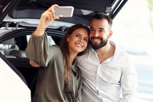 Imagen de una pareja adulta eligiendo un coche nuevo en la sala de exposiciones