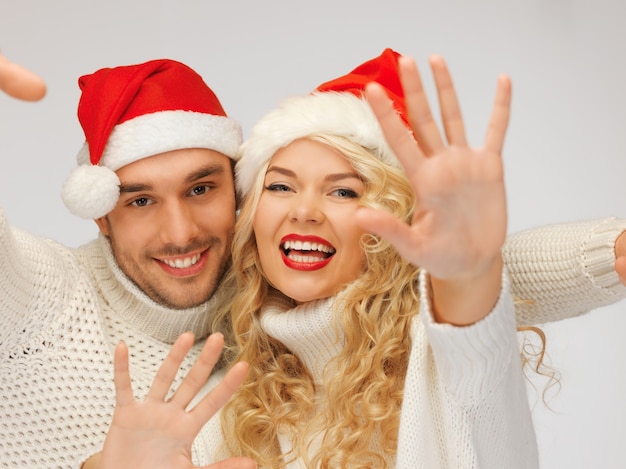 imagen de la pareja de la familia en suéteres y sombreros de santa