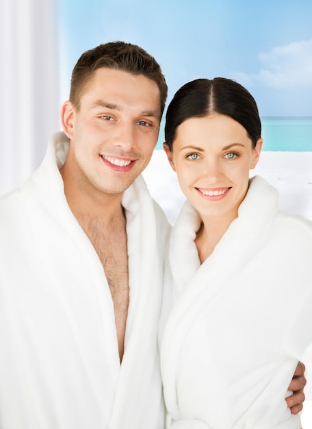 Imagen de una pareja en el salón de spa en albornoces blancos
