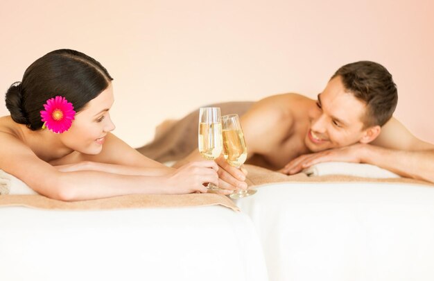 Foto imagen de una pareja en el salón de spa bebiendo champán