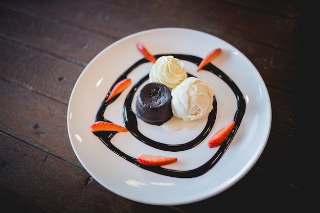 La imagen del pastel de lava de chocolate caliente con helado de vainilla y fresa fresca