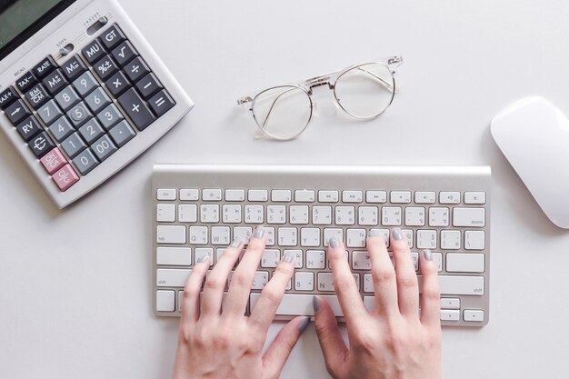 Imagen de una persona usando una computadora portátil en la mesa.