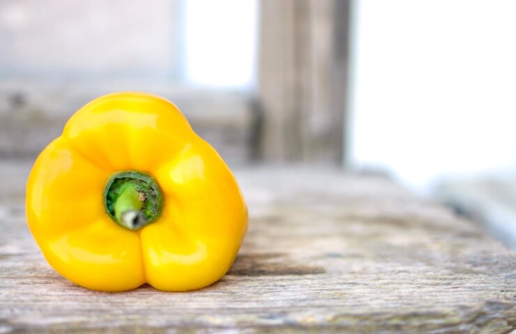 Imagen de pimiento amarillo sobre mesa de madera rústica
