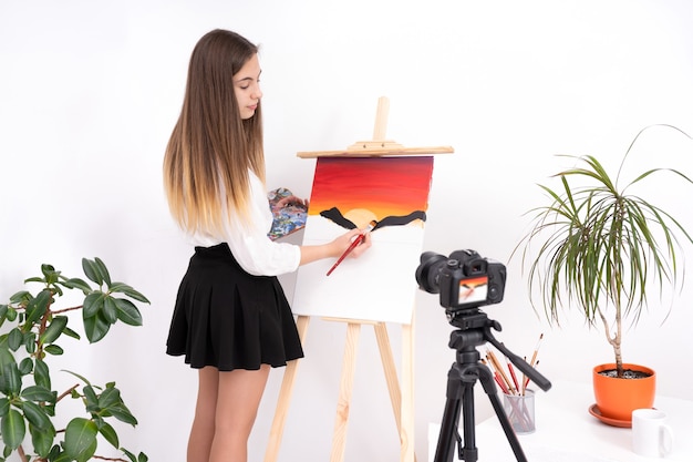 Imagen de pintura de mujer joven creando contenido en línea sobre fondo blanco con espacio de copia