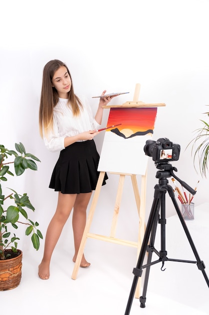 Imagen de pintura de mujer joven creando contenido en línea sobre fondo blanco con espacio de copia