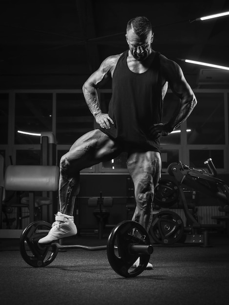 Imagen de un poderoso atleta posando en el gimnasio. Concepto de fitness y culturismo. Técnica mixta