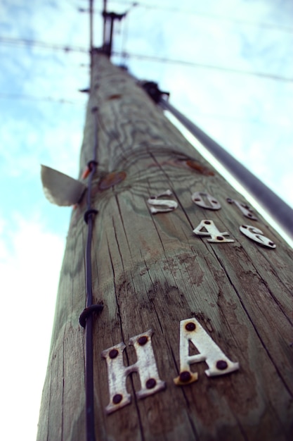 La imagen de un poste de teléfono grande con las letras HA perforadas en su costado se extiende hacia el cielo