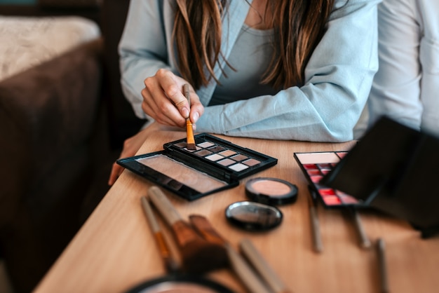 Imagen del primer de la mano del artista de maquillaje y del maquillaje.