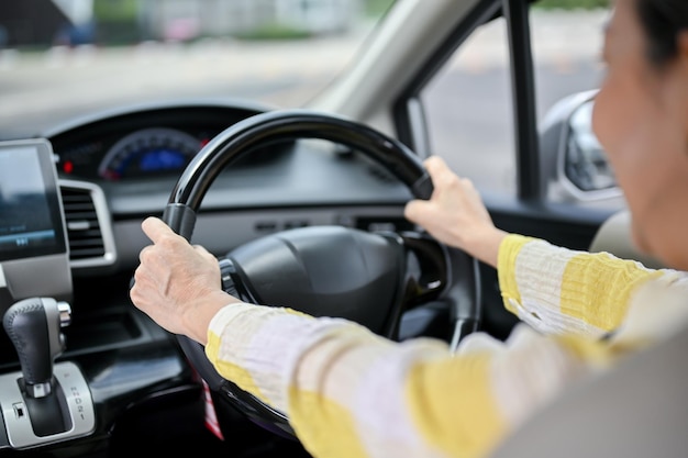 Foto imagen de primer plano de una anciana asiática feliz conduciendo un automóvil automóvil de transporte