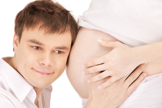 Imagen en primer plano brillante del rostro masculino y el vientre de la mujer embarazada