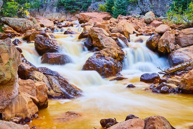 Imagen de primer plano de cascadas en el río lleno de grandes piedras rojas